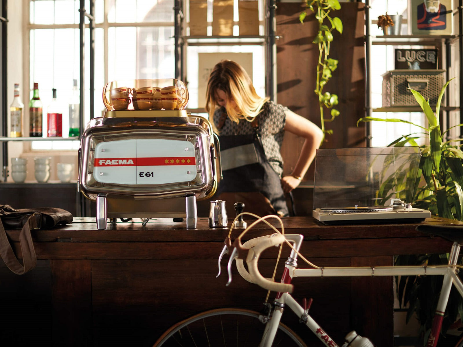 Faema E61 Legend espresso machine rear view in cozy café setting with barista
Page Title: Faema E61 Legend – Rear View in Artisan Café Atmosphere- in its natural habitat—bringing iconic espresso excellence to your café or kitchen.