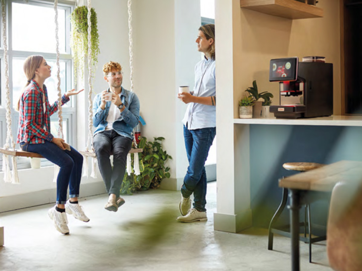 Team enjoying fresh coffee from the S-Lite Espresso Machine in a casual breakroom setting - S-Lite Espresso Machine in Creative Office Breakroom - Bring people together over barista-quality coffee in your office breakroom with the S-Lite.